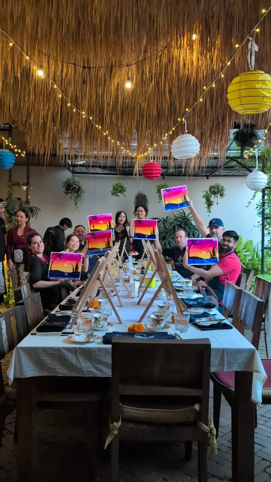Friends smiling with finished paintings after a private Paint and Sip event