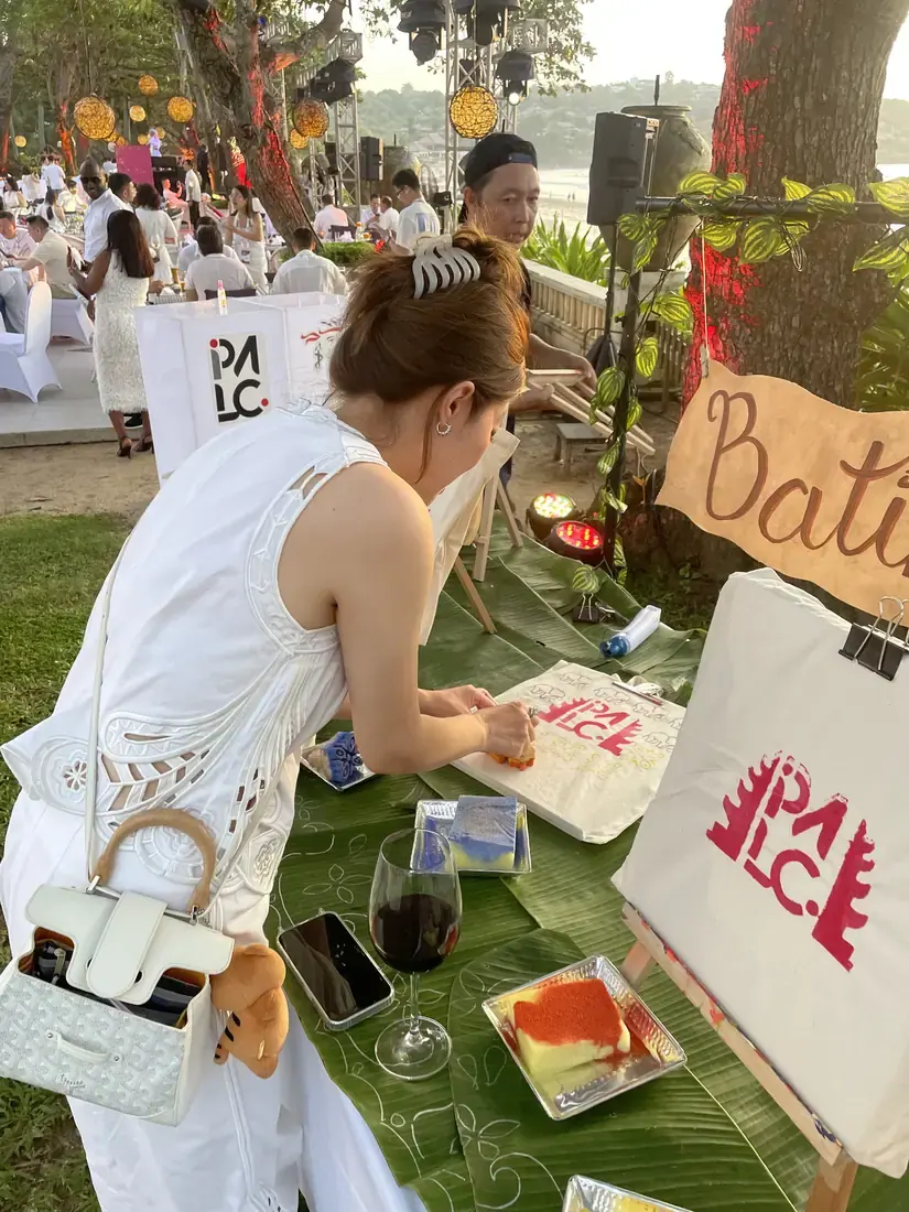 Private paint and sip guest holding finished artwork in Bali