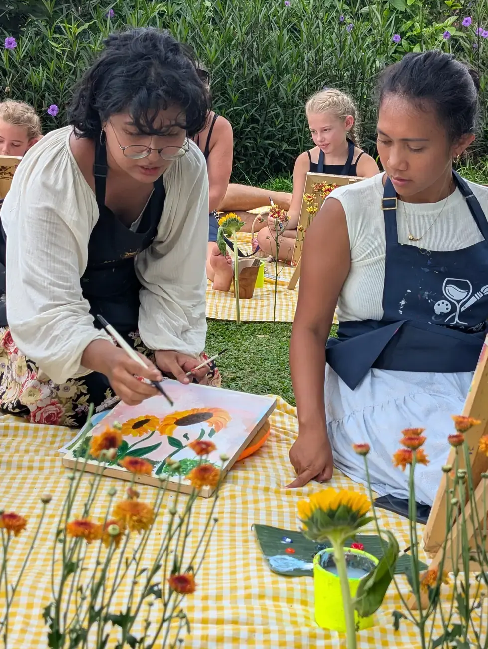 Guest painting during an outdoor picnic paint and sip event
