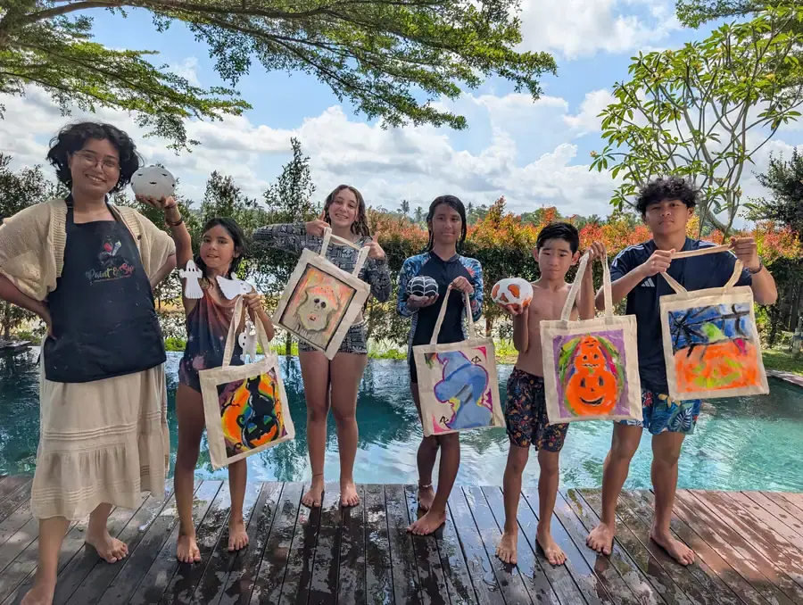 Family group holding painted tote bags at a private Bali event