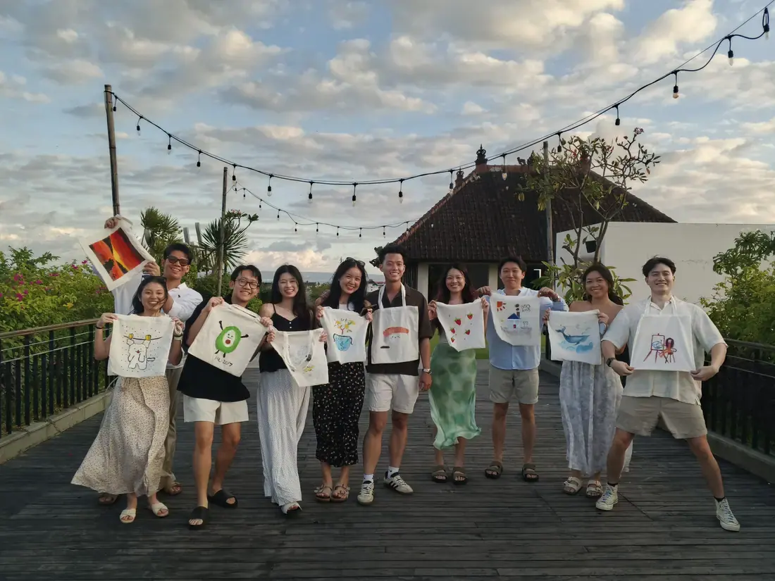Guests posing with paintings at a Bali paint party